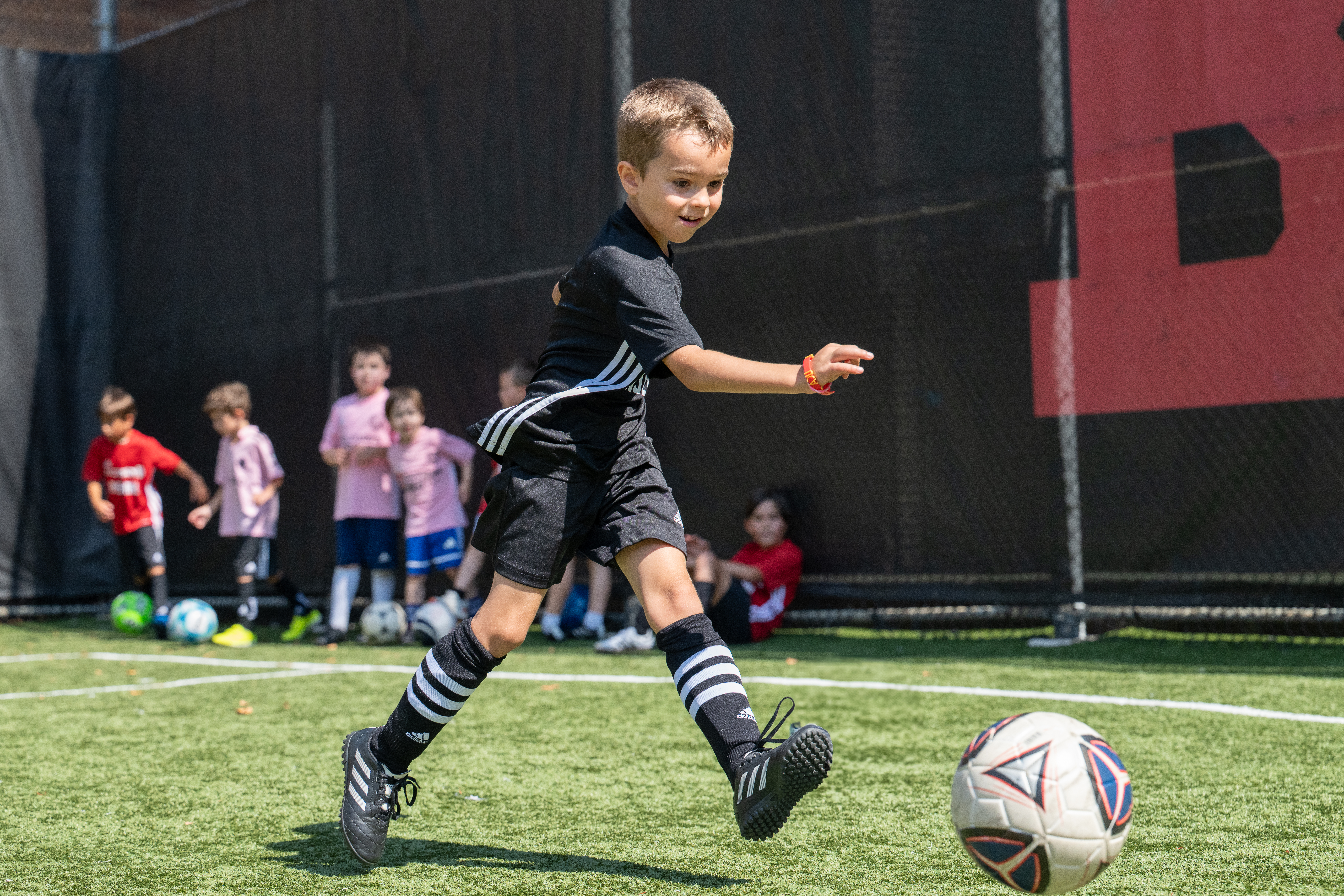 young boy running with soccer ball