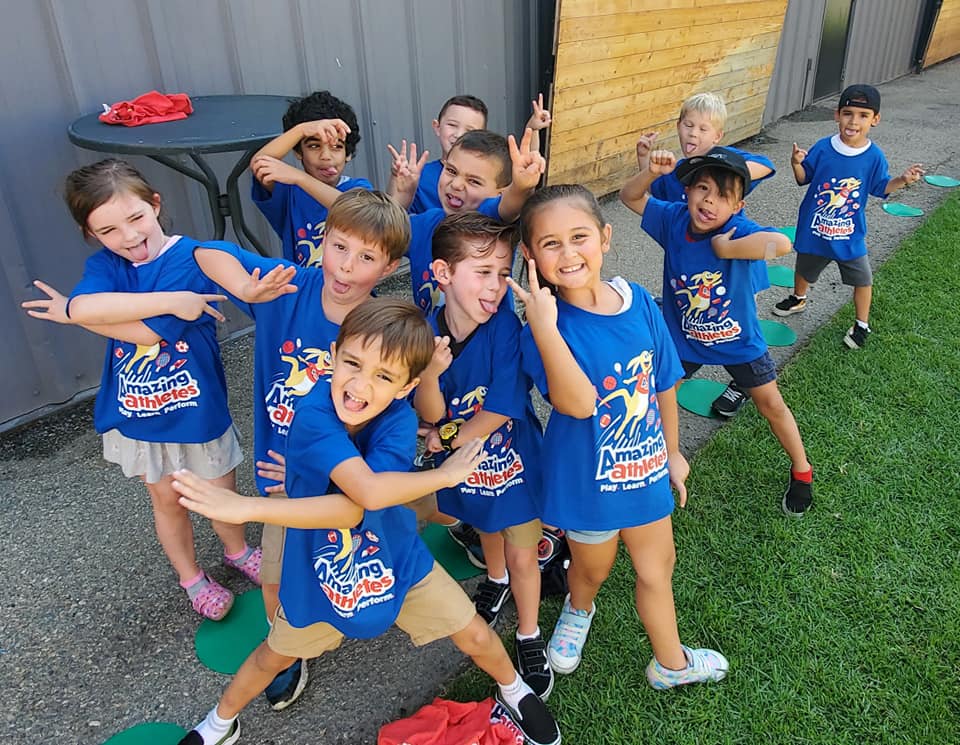 kids soccer group smiling and making funny faces at camera
