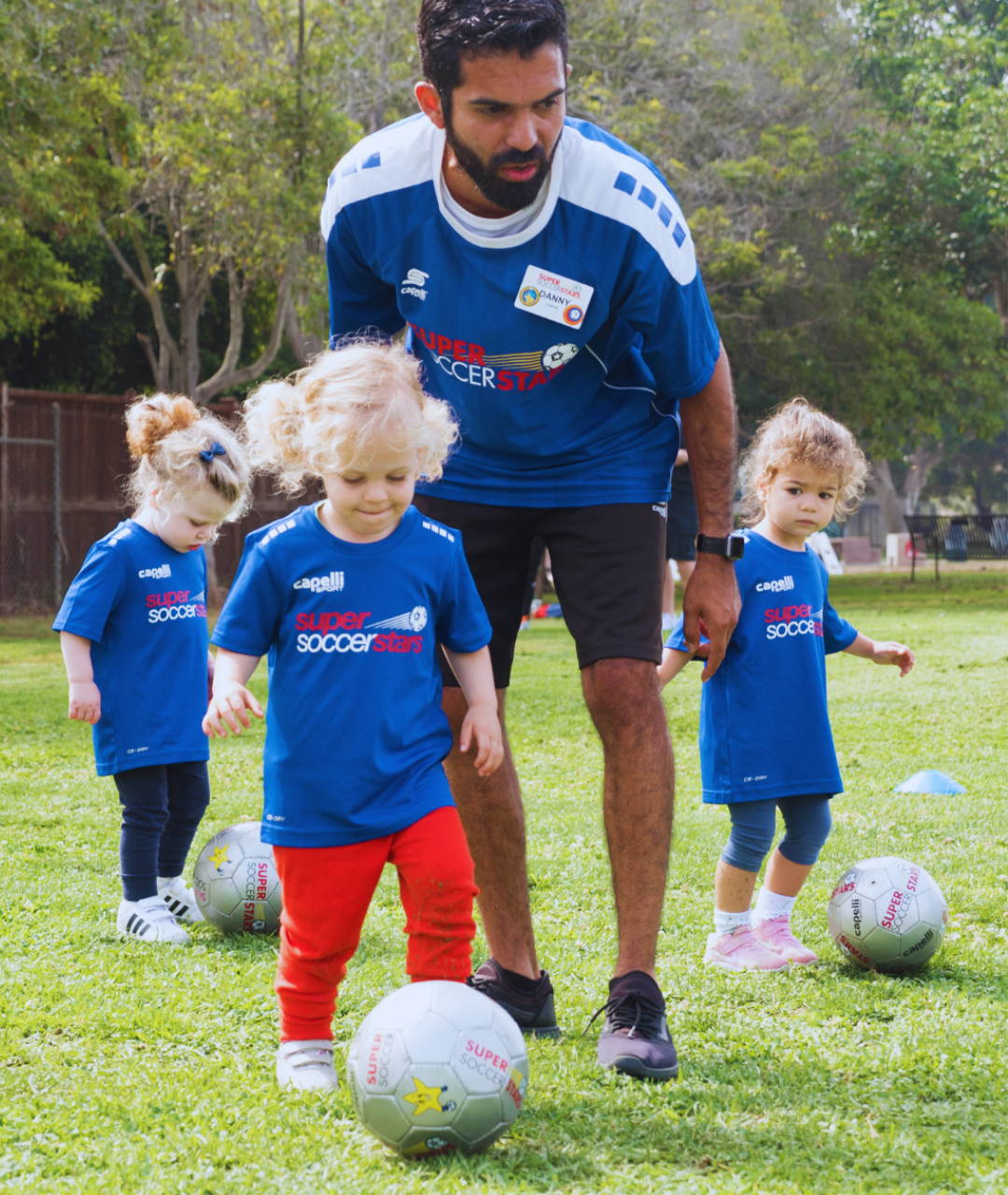Toddler girls playing soccer outside