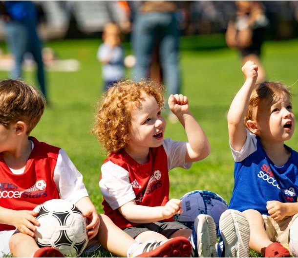Young kids celebrating during a Soccer Stars Brooklyn soccer class